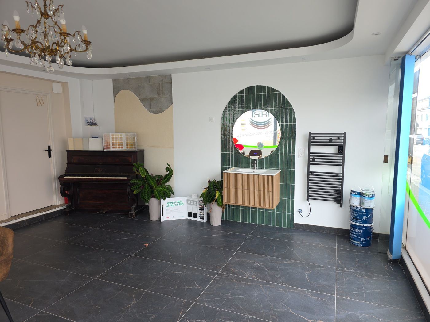 Showroom STB : meuble vasque sur carrelage vert, échantillons d'enduits et nuanciers de peinture