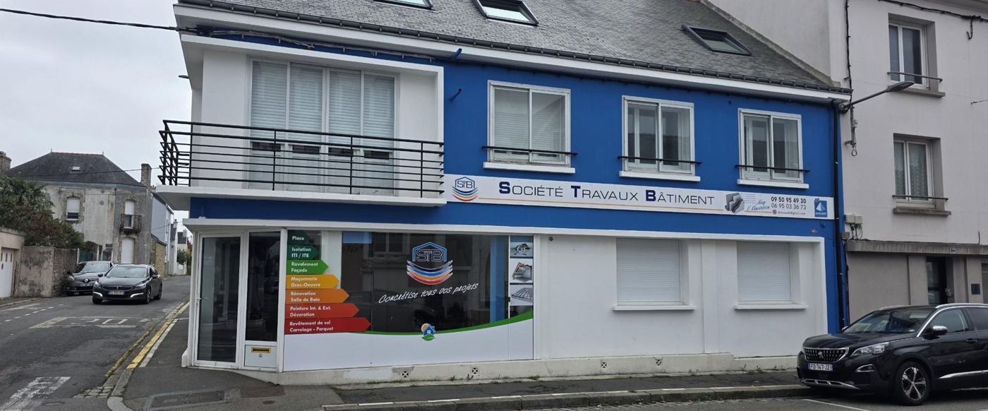 Façade de l'agence STB, peinte en bleu, avec l'enseigne Société Travaux Bâtiment